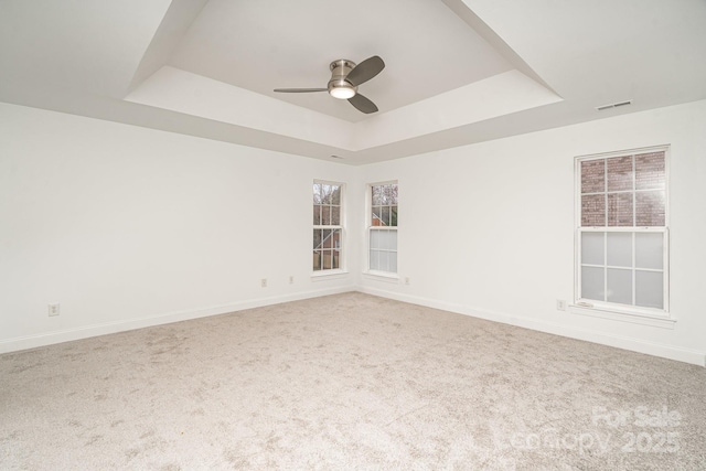 spare room featuring baseboards, a tray ceiling, and carpet flooring