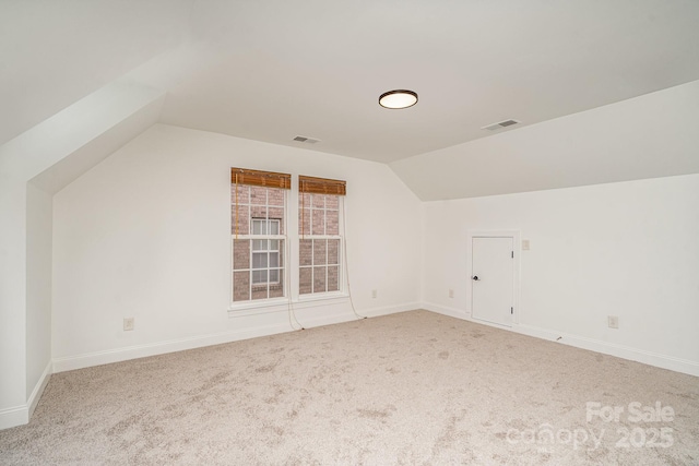 bonus room featuring carpet floors, visible vents, vaulted ceiling, and baseboards