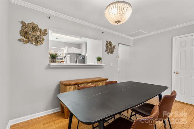 dining area featuring light wood-type flooring, baseboards, and ornamental molding