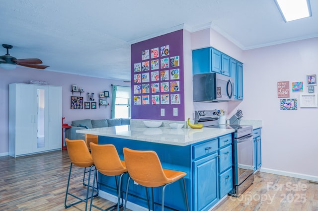91 Congress St, Asheville, NC 28801 - kitchen featuring blue cabinetry, a breakfast bar area, light wood-style floors, and electric stove
