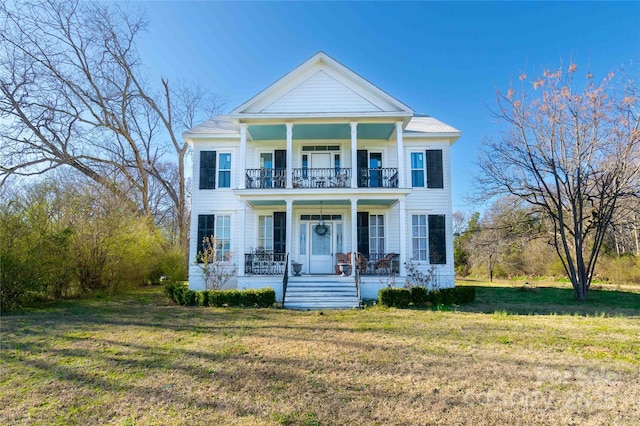 neoclassical / greek revival house featuring a balcony, covered porch, and a front lawn