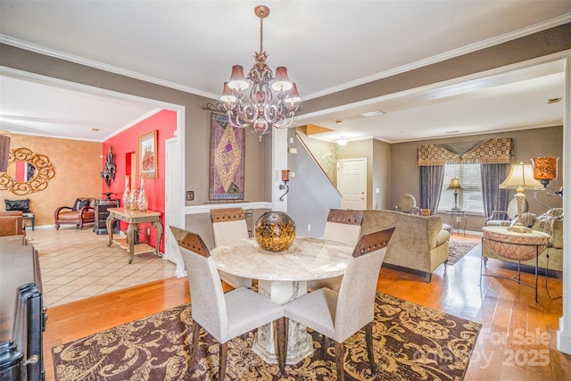 dining area featuring baseboards, an inviting chandelier, wood finished floors, and ornamental molding