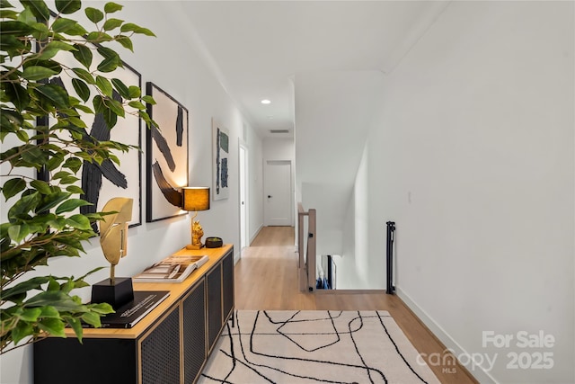 hallway featuring recessed lighting, light wood-type flooring, an upstairs landing, and baseboards