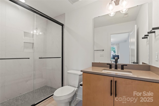 bathroom with a stall shower, visible vents, vanity, and toilet