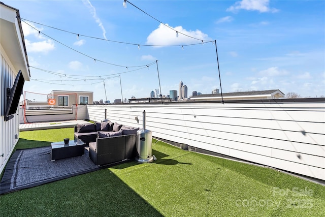 view of yard with fence, outdoor lounge area, and a city view