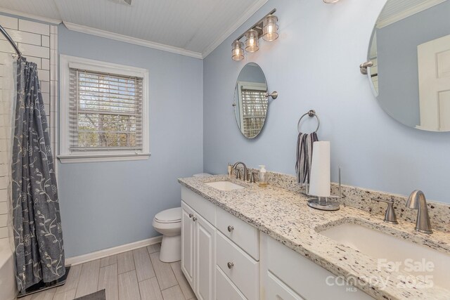 full bathroom featuring toilet, a sink, crown molding, and baseboards