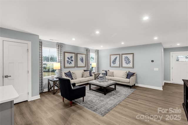 living room with recessed lighting, baseboards, and wood finished floors