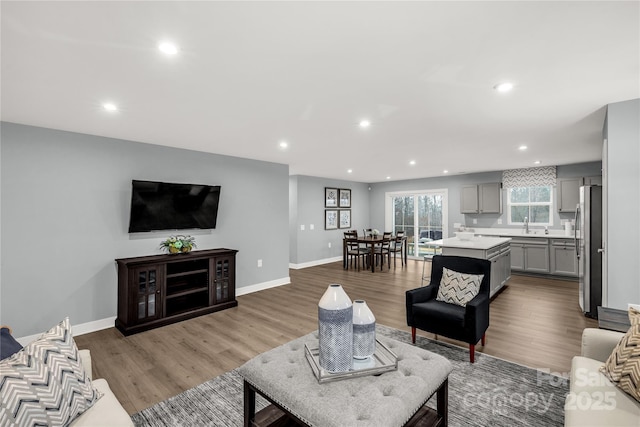 living area featuring recessed lighting, wood finished floors, and baseboards