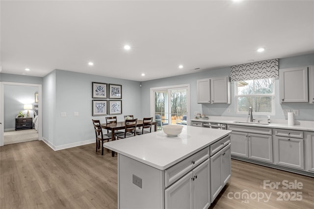 kitchen featuring light wood finished floors, plenty of natural light, and a sink