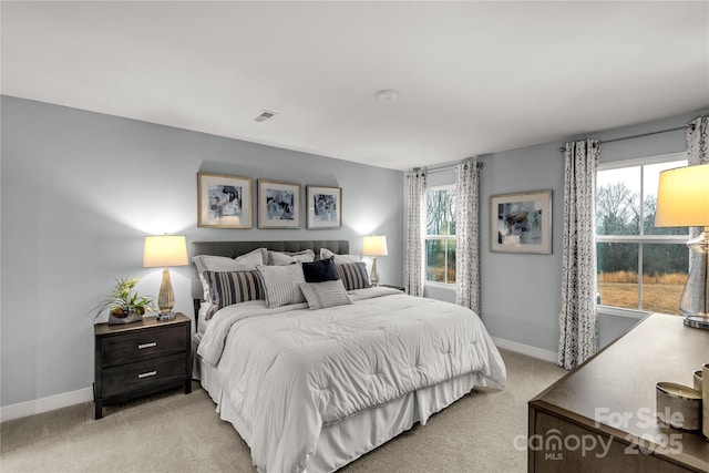 bedroom featuring light carpet, visible vents, and baseboards