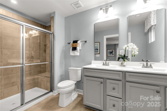 full bath featuring toilet, a sink, visible vents, and a shower stall