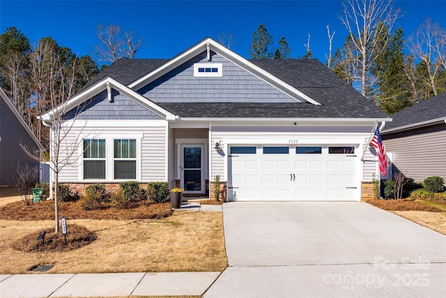 craftsman-style home featuring concrete driveway, roof with shingles, and an attached garage