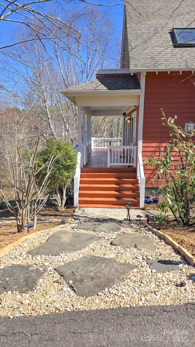 exterior space featuring covered porch and a shingled roof