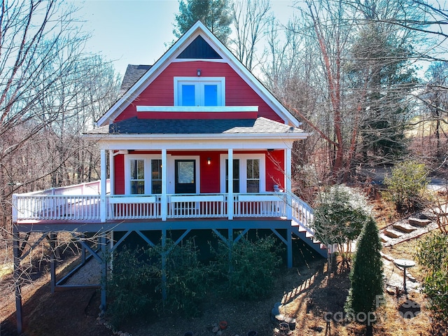 view of front of home featuring a shingled roof and stairway