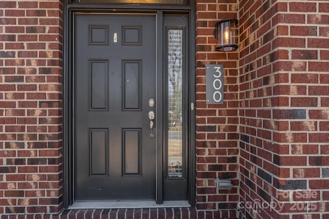 view of exterior entry with brick siding