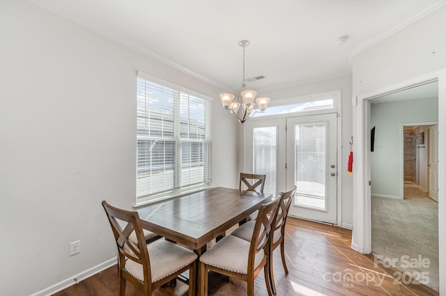 dining room with crown molding, baseboards, and wood finished floors