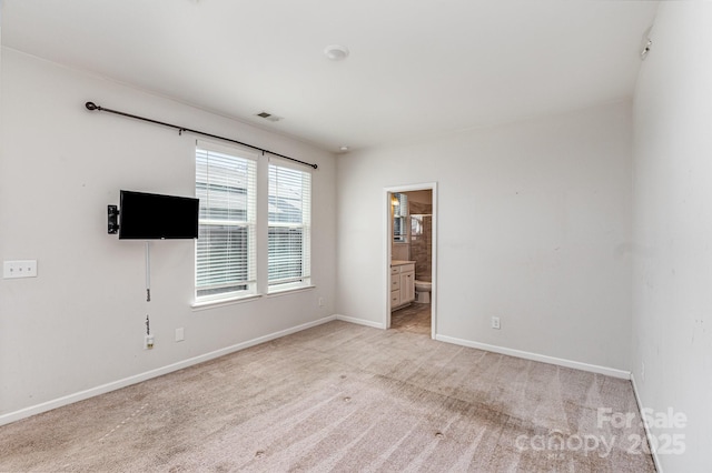 interior space with baseboards, visible vents, and light carpet