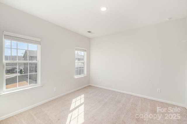 carpeted spare room with visible vents, recessed lighting, and baseboards