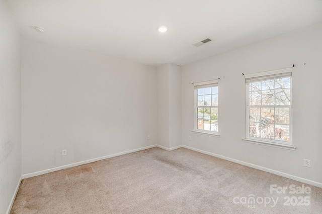 spare room with visible vents, carpet floors, and baseboards