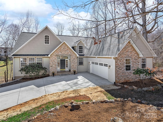 view of front of property featuring an attached garage, stone siding, a shingled roof, and concrete driveway