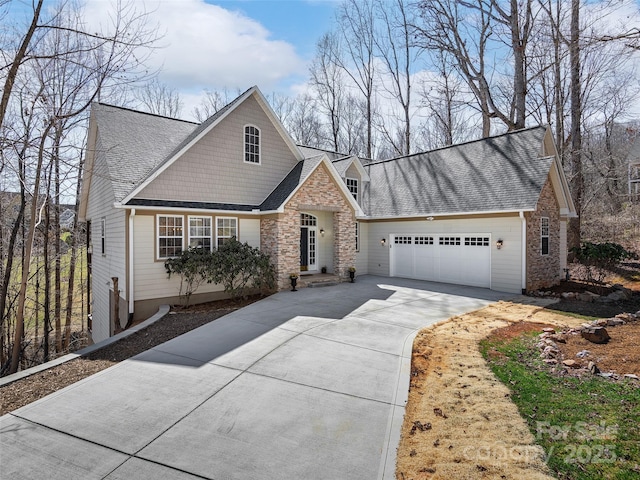 view of front facade with a garage, stone siding, a shingled roof, and concrete driveway