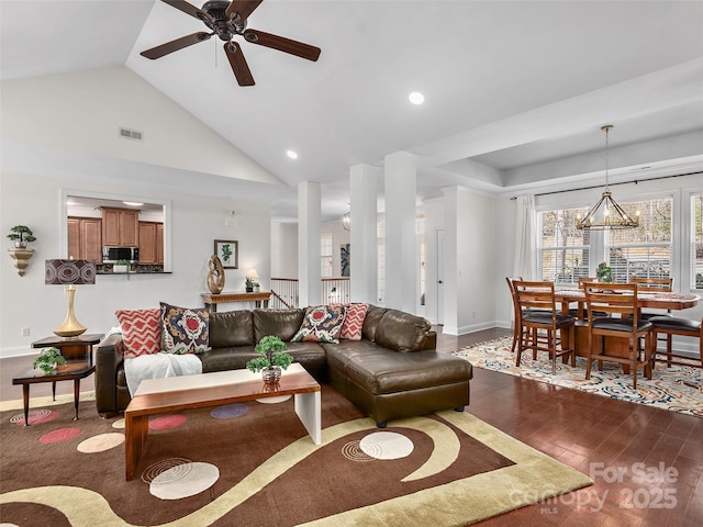 living room with high vaulted ceiling, visible vents, baseboards, and wood finished floors