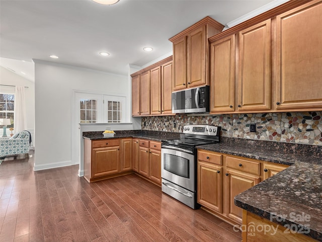 kitchen with dark wood-style floors, backsplash, appliances with stainless steel finishes, ornamental molding, and baseboards