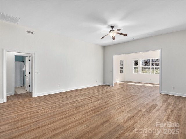 spare room featuring ceiling fan, light wood-type flooring, and visible vents