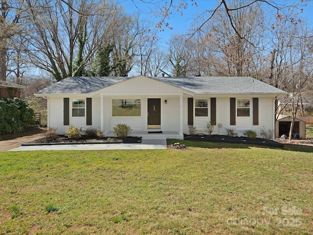 single story home featuring a shingled roof and a front yard