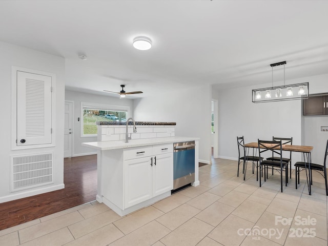 kitchen featuring visible vents, white cabinets, a ceiling fan, dishwasher, and pendant lighting