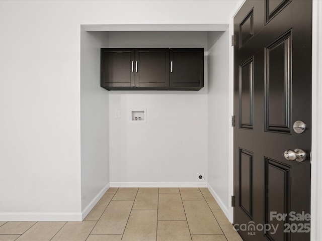 washroom with cabinet space, baseboards, light tile patterned floors, and washer hookup