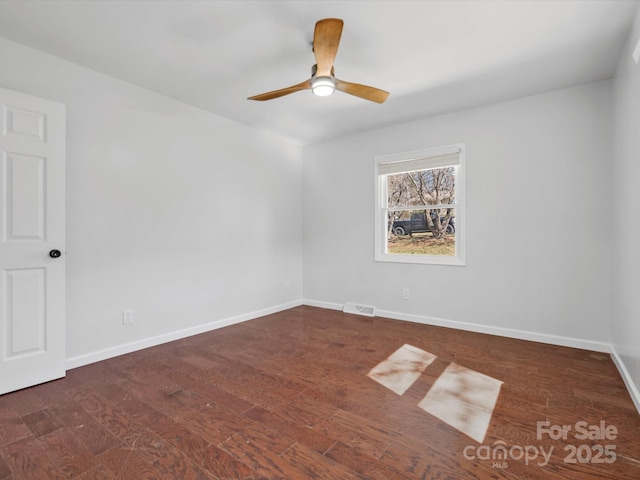 unfurnished room featuring baseboards, visible vents, ceiling fan, and wood finished floors