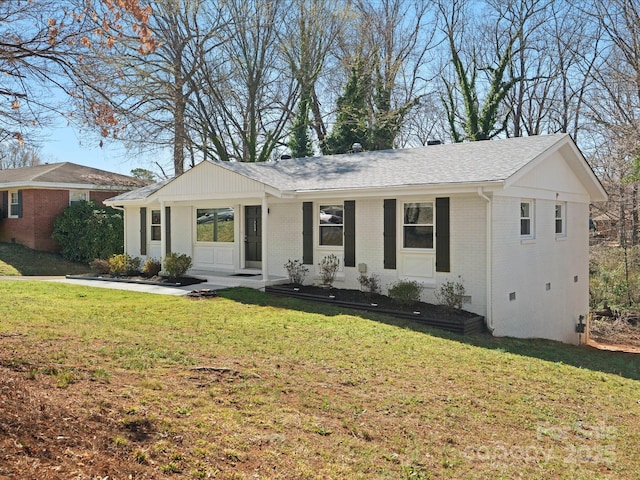 ranch-style home with crawl space, a shingled roof, a front yard, and brick siding