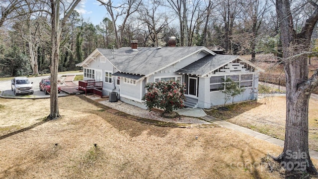 exterior space with central air condition unit, driveway, and a wooden deck