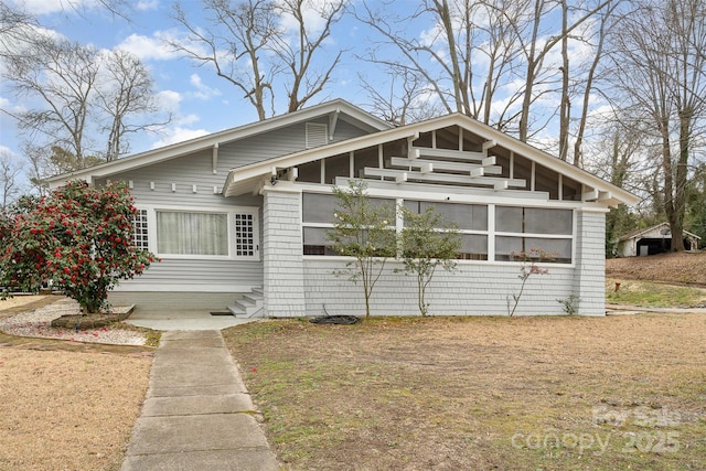 view of front of property with entry steps and a sunroom