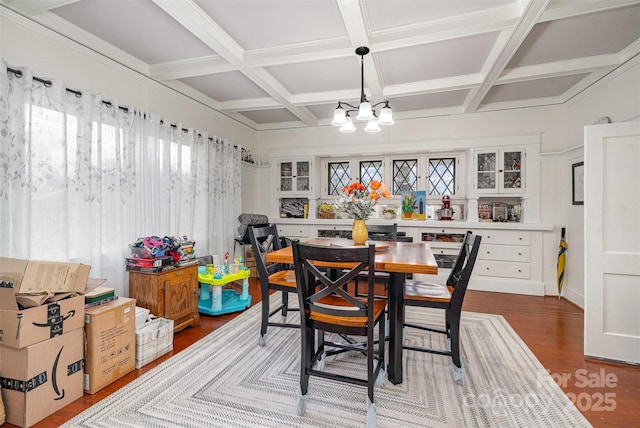 dining space featuring beamed ceiling, coffered ceiling, dark wood finished floors, and a notable chandelier