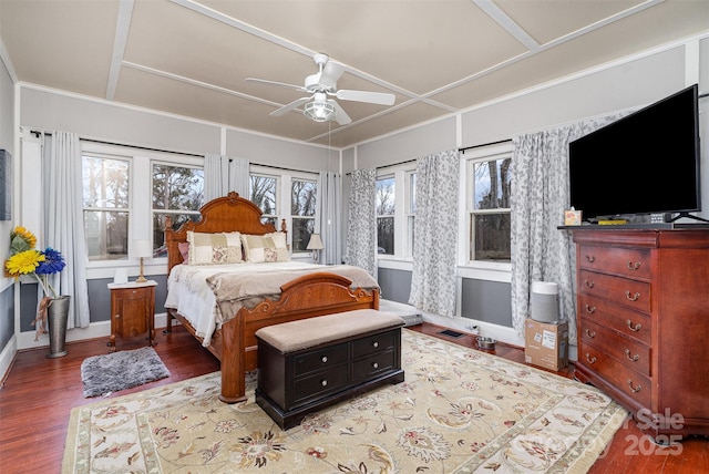 bedroom with multiple windows, wood finished floors, and baseboards