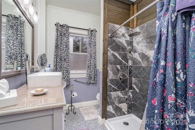 full bathroom featuring crown molding, toilet, a stall shower, vanity, and baseboards