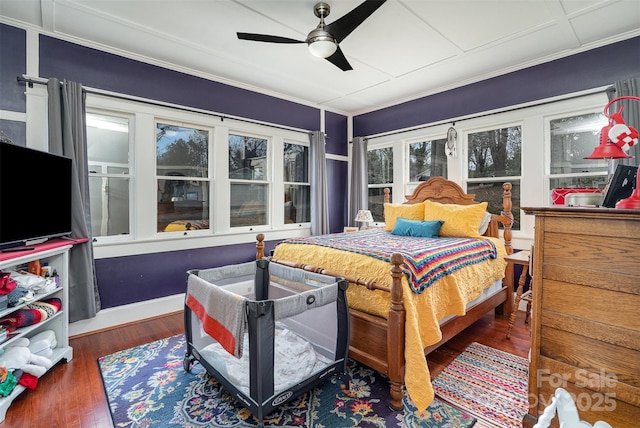 bedroom with ornamental molding, ceiling fan, and wood finished floors