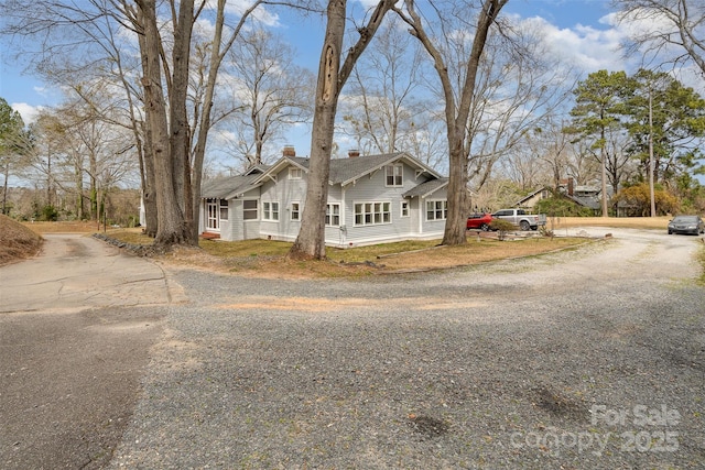 exterior space featuring driveway and a chimney