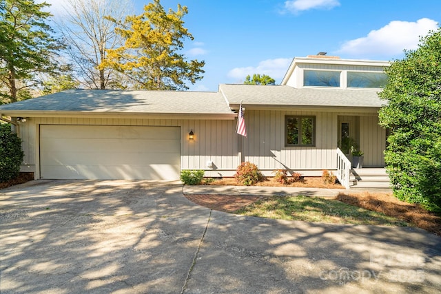 view of front of home with concrete driveway, a shingled roof, and an attached garage