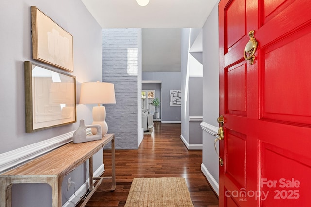 entryway with dark wood finished floors and baseboards