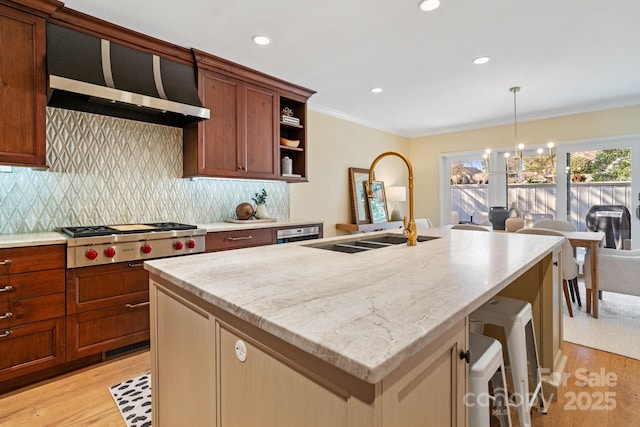 kitchen featuring crown molding, range hood, stainless steel gas cooktop, and light wood-style flooring