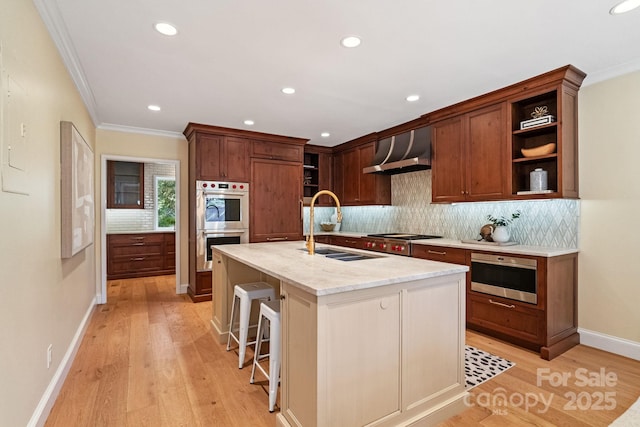 kitchen with open shelves, light wood-style floors, wall chimney exhaust hood, and stainless steel appliances