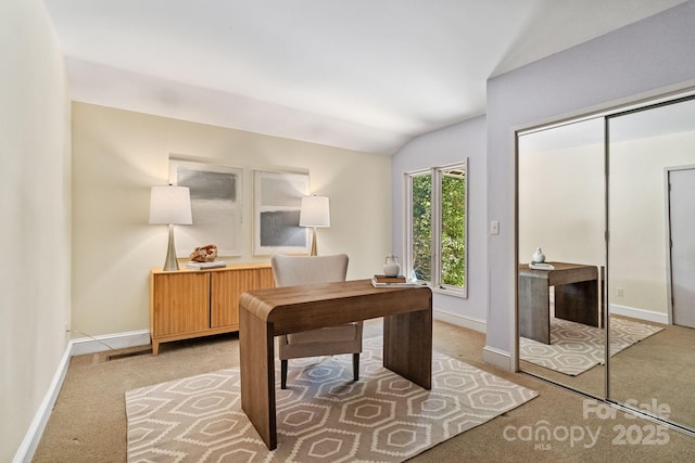 office featuring light carpet, baseboards, and vaulted ceiling