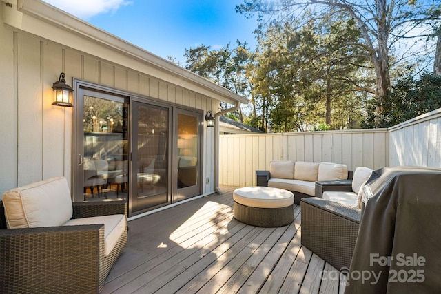 wooden deck featuring a grill, fence, and an outdoor hangout area