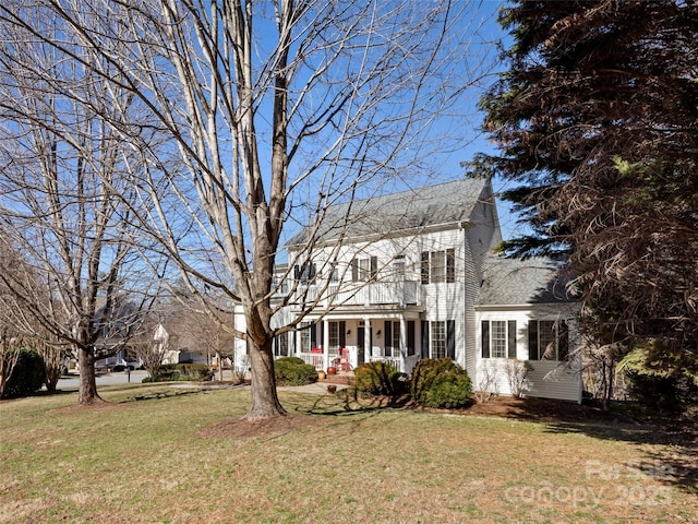 view of front of home featuring a porch, a shingled roof, a balcony, and a front lawn