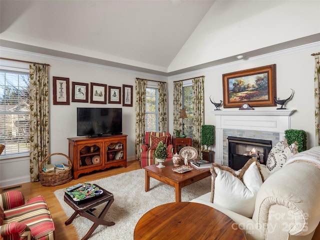 living area featuring a healthy amount of sunlight, a fireplace, visible vents, and wood finished floors