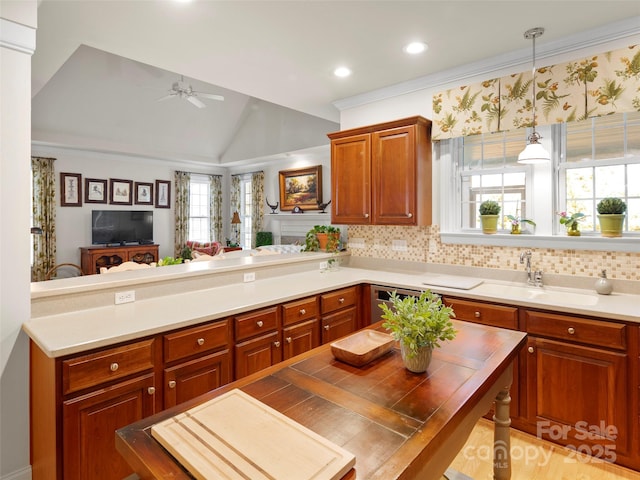 kitchen with lofted ceiling, light countertops, a ceiling fan, open floor plan, and a peninsula