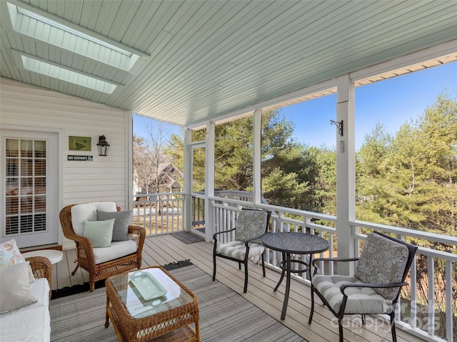 sunroom / solarium featuring a healthy amount of sunlight and vaulted ceiling